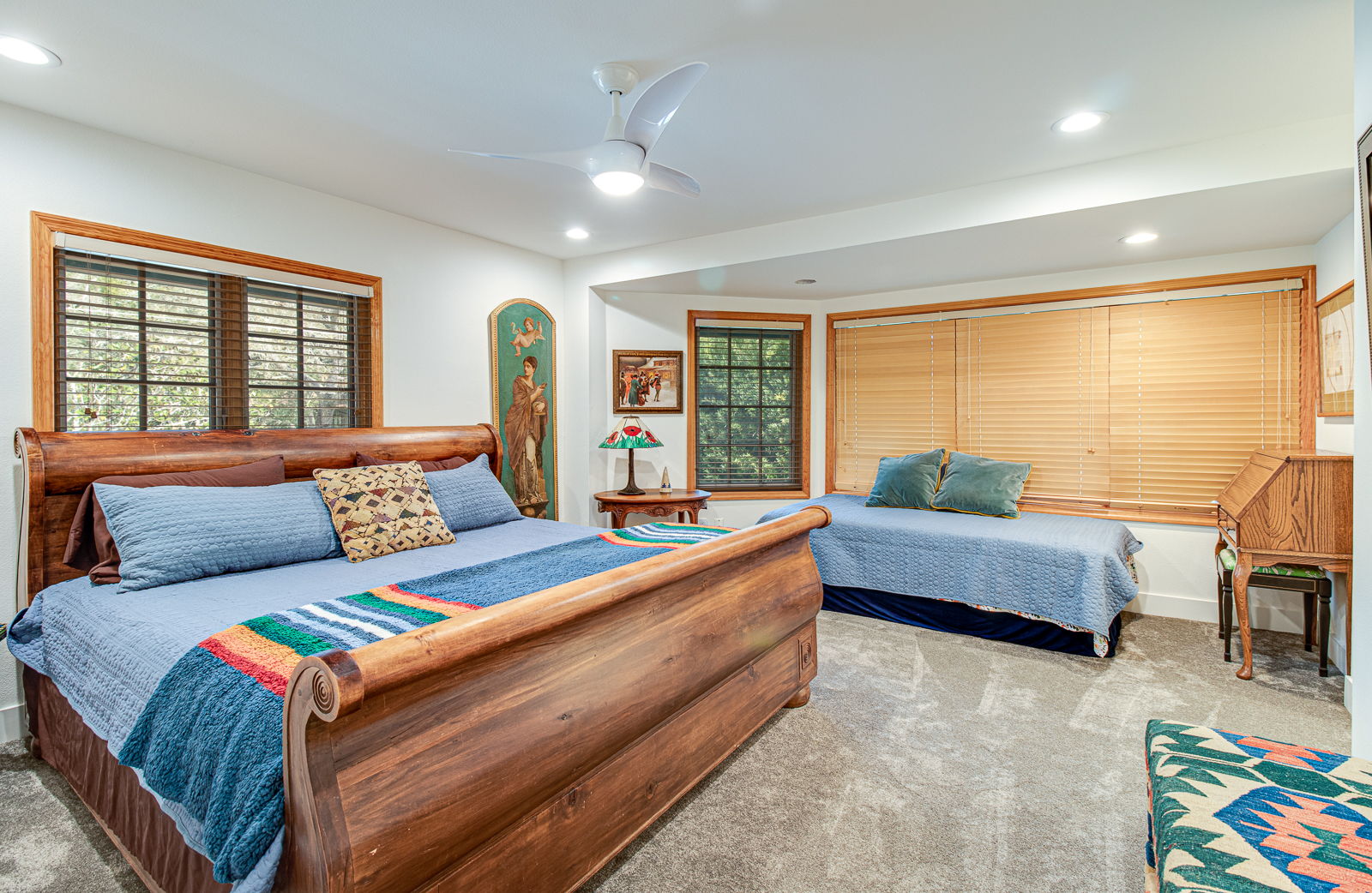 Restful guest bedroom with warm wood furnishings and shuttered windows