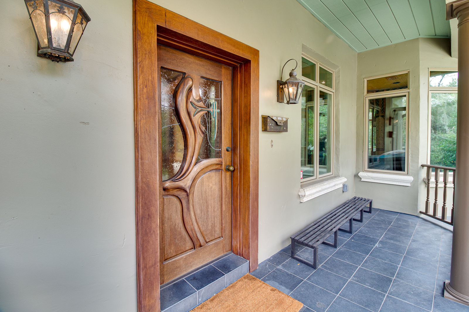Hand-carved wooden front door at the entrance of the retreat house