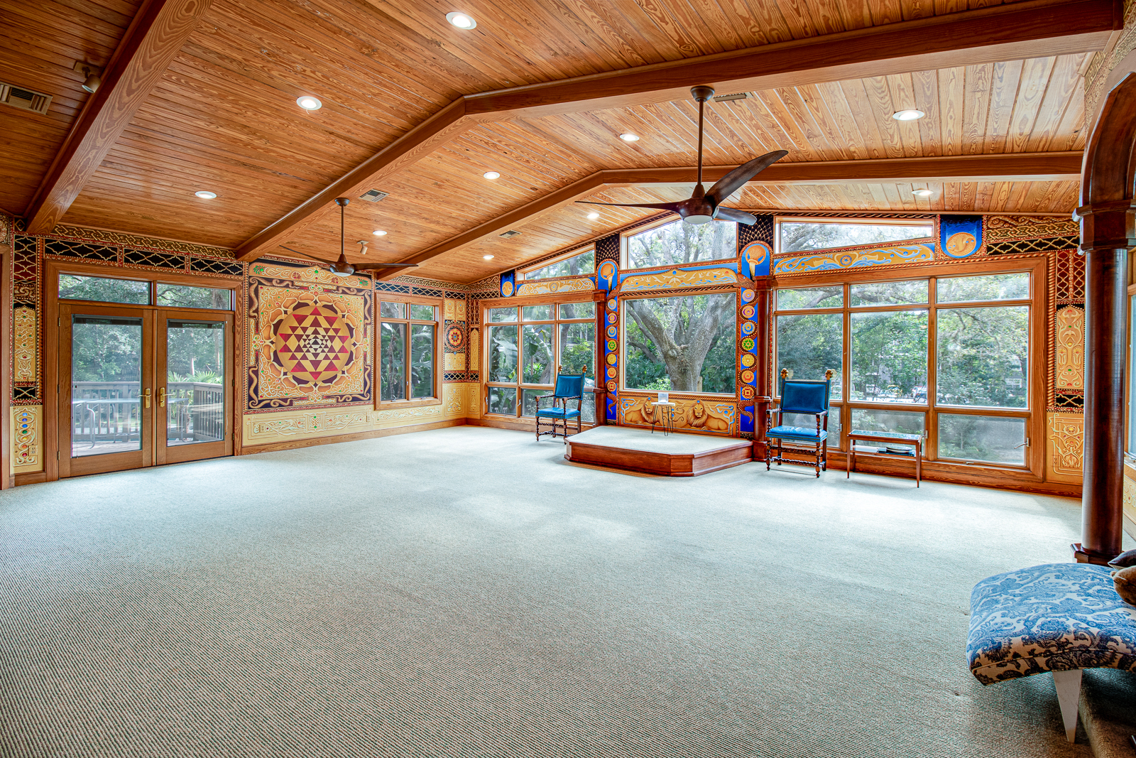 Light-filled gathering room with vaulted wood ceiling and garden views